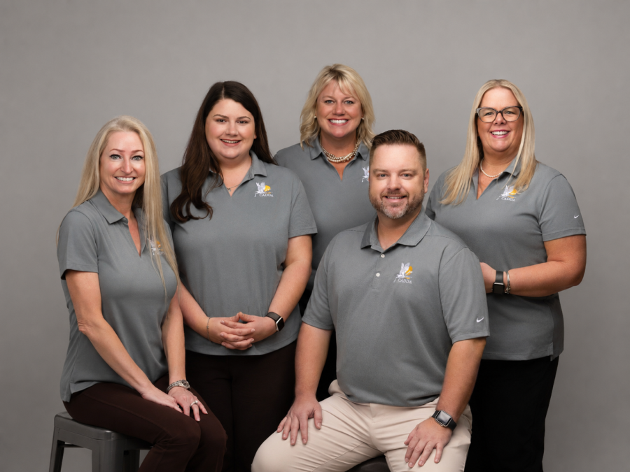Photo of the CADDA staff with branded shirts and grey background